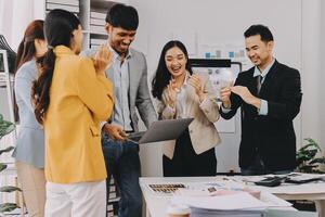 Business people clapping and smiling at a desk photo