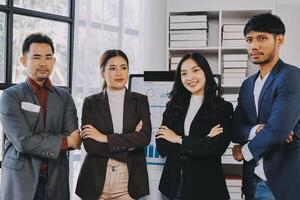 Asian business people standing in front of a computer screen photo