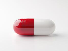 Large red and white capsule resting on a clean surface photo