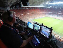 Broadcast team operates controls during a major soccer match photo