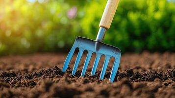 Close-Up of Garden Fork Digging into Rich Dark Soil in Garden photo