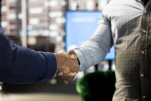 Company manager attending briefing meeting with CEO to share new ideas for profit growth, shaking hands, finalizing deal. Close up of man talking to director, doing handshake reaching agreement photo