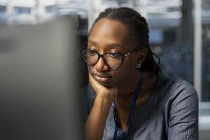Bored data center technician at work inspecting gear, doing monotonous maintenance tasks. Weary woman in server farm employee conducting system checks to ensure operational stability photo