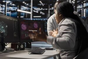 Technicians in data center viewing hacking security breach alert of zero day exploit vulnerability. Cybersecurity colleagues doing brainstorming to trace intrusion origin and apply emergency patches photo