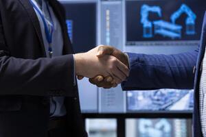 Investor shaking hands with factory manager after finding no safety issues, closing deal. Shareholder doing handshake with man after analyzing industrial plant potential risks, agreeing terms, closeup photo