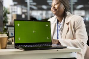 African american office worker verifying data analytics with copy space, using monthly infographics to create a financial report. Woman collecting performance metrics on computer. photo