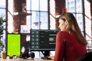 Woman uses AI chat interface on a computer next to chroma key, assisting with problem solving and task completion. Virtual chatbot assistant leverages artificial intelligence and automation. photo