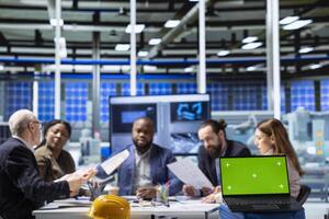 Factory company shareholders analyzing data, reviewing system health metrics with mockup laptop. Industrial plant investors in office troubleshooting issues using chroma key notebook photo