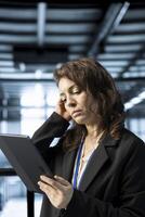 Computer scientist in data center with tablet integrating automation tools, running predictive maintenance routines. Woman ensuring continuous uptime of server room, managing data flows with device photo