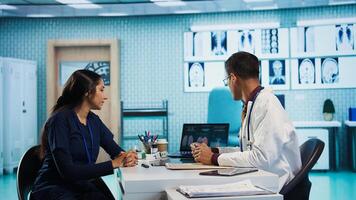 Indian general practitioner and patient engage in a medical consultation with diagnostic tools and x ray text results for scan interpretation. Showcasing healthcare practices and research. Camera B. photo