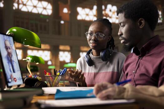 Diverse students team engaging in a call with a doctor, learning about medical topics and methods. Medicine pupils utilizing telemedicine tools for remote learning in a university library. photo