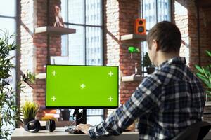 Freelancer in home office completing spreadsheets on mockup computer, entering data, calculating totals. Remotely working accountant analyzing figures on green screen PC, using spreadsheet software photo