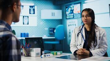 Medical expert and patient discussing diagnostic results in a modern cabinet, establishing advanced healthcare tools to present x ray imaging scans. Insurance management. Camera B. photo
