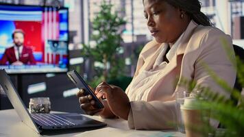 Black entrepreneur discussing about updates or business ideas with her staff, shares project insight via text messages on internet connection. Successful goal oriented black CEO. Camera B. photo