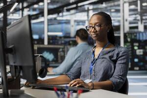 Data center programmer analyzing software logs metrics on PC, optimizing storage infrastructure. Server farm facility IT professional inspecting resource utilization, managing application efficiency photo