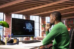 Admin writing code on PC and doing maintenance on artificial intelligence neural networks computerized model. African american tech support expert typing on keyboard, doing checkup on AI systems photo