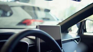 Close up of car interior with steering wheel and infotainment system screen. Panning shot of integrated multimedia vehicle computer inside automobile combining functions improving driving photo