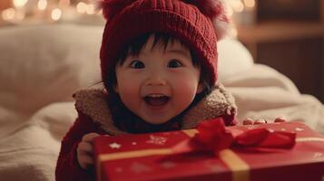 A joyful baby, wrapped in warmth, holds a Christmas present. photo