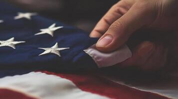Close-up view of a hand gently touching an American flag. photo