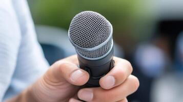 Close-up of a person's hand holding a microphone. photo