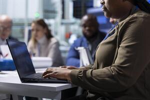 Factory management and shareholders work on manufacturing automation innovations using notebook, close up. Industrial plant managers and investors analyze production research data using laptop photo