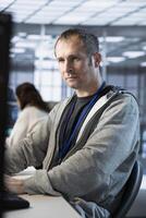 Computer scientist in server farm ensuring compliance with industry standards and regulatory requirements. Data center worker using PC, conducting security audits to protect against cyberthreats photo