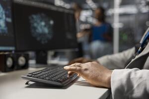 Close up of server hub engineer typing on PC keyboard, looking at data visualization to pinpoint performance issues. Data center worker writing code to reduce hardware failures photo