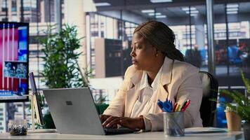 African american CEO driven by empowerment and ambition in her office, focuses on achieving business targets and enhancing company performance in a dynamic corporate setting. Success story. Camera A. photo