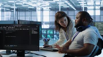 Manager showing admin how to finish tasks in data center providing resources for different workloads. Team leader teaching IT specialist how to while monitor AI supercomputers, camera A photo