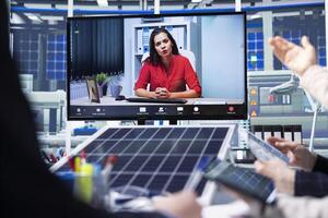 Photovoltaics factory team in remote videoconference meeting improving development efficiency. Solar panels plant employees in office studying how to harness sun power during internet call photo