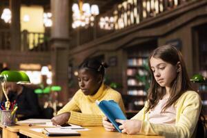 Diverse teenagers engrossed in reading books at the school library, focusing on literature and knowledge while they are preparing for their academic lessons and school assignments. photo