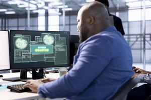 Access granted notification on monitor received by man reconfiguring server hub, optimizing it. African american data center IT expert using PC to successfully eliminate all errors photo