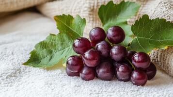 Fresh red grapes with leaves on a soft cloth. photo