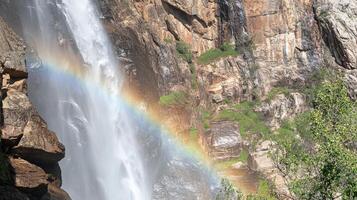 Majestic waterfall with vibrant rainbow cascade. photo