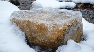 Frozen stone block surrounded by snow and ice. photo