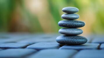 A delicate stack of stones balanced on a paved surface. photo