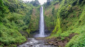 Lush waterfall cascading down a green mountain valley. photo