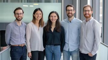 Five people in casual business attire stand together. photo