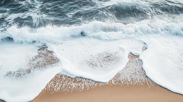 Foamy waves gently lapping on a sandy shore. photo