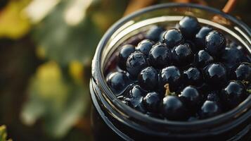 Close-up view of dark berries in a glass jar. photo