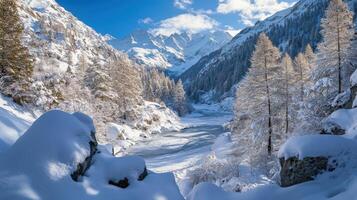 Snowy mountain valley scene with frozen river and trees. photo