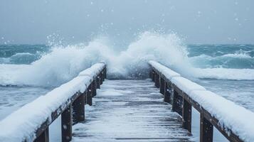 Powerful winter waves crashing over a snowy pier. photo