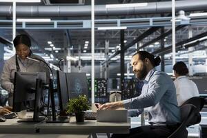 Upset engineer in data center packing personal items at workstation after being replaced by AI. Technician removing belongings from server hub workplace desk, fired by artificial intelligence photo