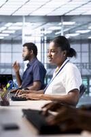 Cheerful engineer reconfiguring server farm to optimize it for data processing requirements of customers. Joyous woman working to ensure data center equipment operates efficiently photo