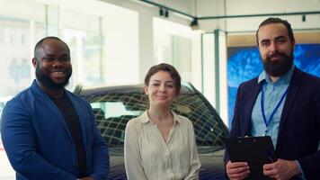 Portrait of cheerful salesman closing deal with customers after negotiating price and extra car features. Happy showroom agent shaking hands with clients after persuading to make purchase, camera A photo