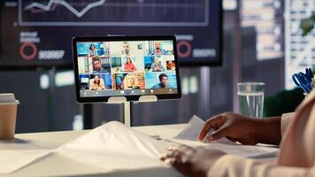 African american CEO sharing sales insight on videocall with forecast affiliates, discussing about profit and analytics in a high end office. Entrepreneur looking to expand her enterprise. Camera A. photo