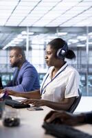 Woman in data center wearing headphones, running system diagnostic tests on PC. Worker listening music, deploying and error checking utilities on computer to fix network issues performance photo