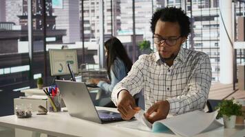Successful entrepreneur working on financial forecasts at his desk, using data and technology to manage business tasks and project development. Company progresses toward its goals. Camera B. photo