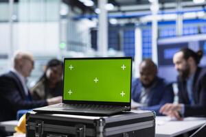 Factory scientists doing research and development, working on manufacturing automation using mockup laptop. Industrial plant experts analyze technical data on chroma key notebook photo