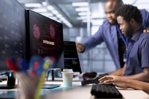 Server hub coworkers working together to protect hardware from hacker attack stealing info. Team of data center computer scientists trying to erase virus after seeing security breach alert on monitor photo